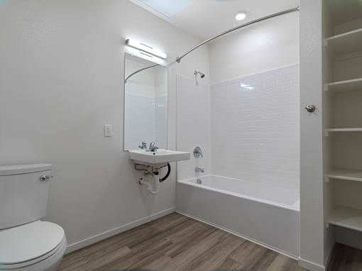 A white bathroom with a toilet, sink, and bathtub.
