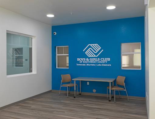 A room with a blue wall and a table with two chairs.