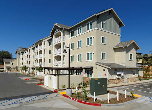 A large apartment complex with a parking lot in front.