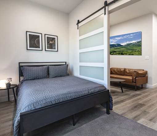 A bedroom with a four poster bed and a couch.