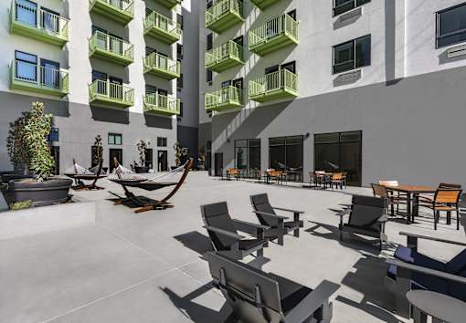 A modern courtyard with black chairs and tables.