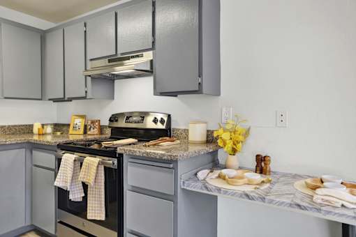 A kitchen with a black stove top oven and a marble counter top.