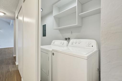 A white washing machine and dryer in a small laundry room.
