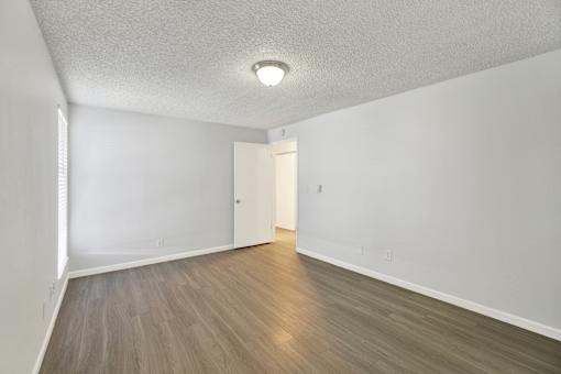 A room with a light brown floor and a white ceiling with a light fixture.