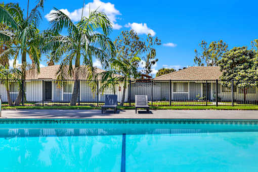 Swimming pool with lounge chairs and fencing at Coventry Square Apartments, Upland, 97186
