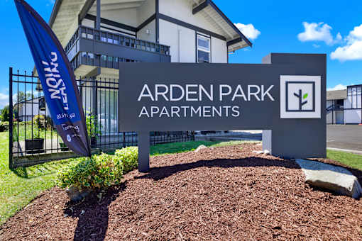 A sign for Arden Park Apartments is displayed in front of a building.