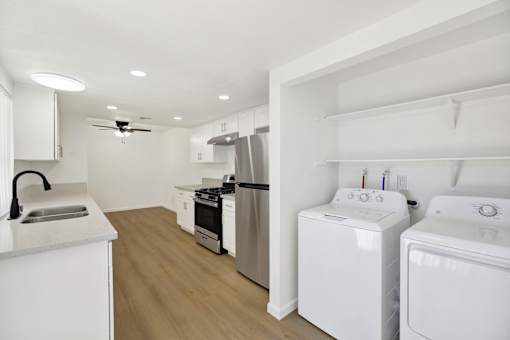 Kitchen with laundry room and modern appliances at Coventry Square Apartments, Upland, 97186