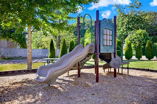 A playground with a slide and a swing set.