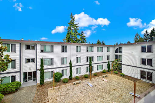 Apartment complex with a courtyard and trees.