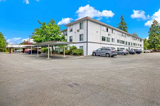 A large white building with a parking lot in front of it.