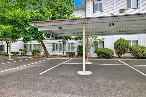 A parking lot with a white canopy and number 115 on it.