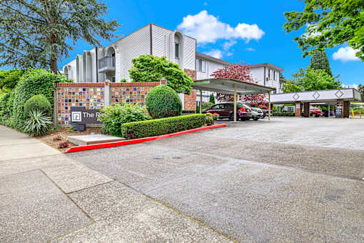 A parking lot in front of a building with a sign that reads "The Ridge".