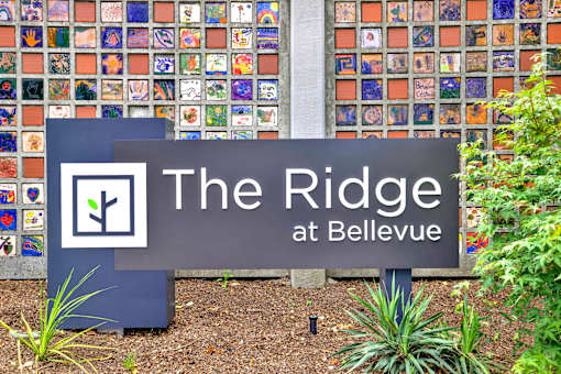 A sign that says The Ridge at Bellevue in front of a wall of tiles.