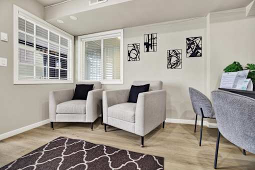 Three chairs are placed in a room with a white wall and a window.