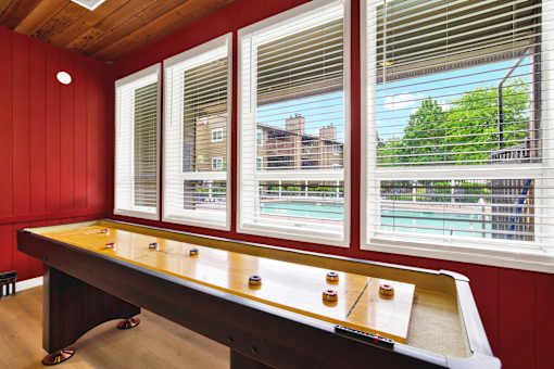 A pool table in a room with red walls and a window.