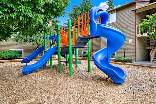 A blue and orange slide in a playground.