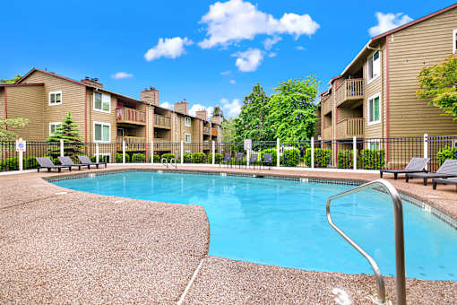 A swimming pool in front of apartment buildings.