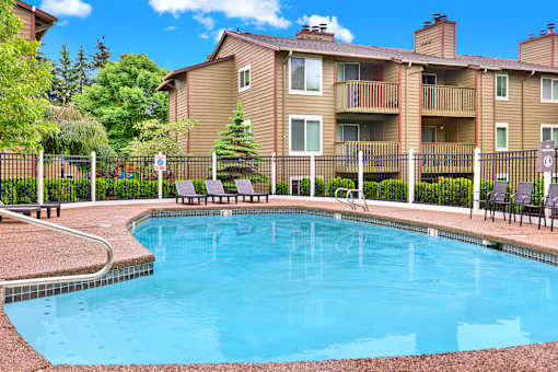 A small pool in front of a building with a fence around it.