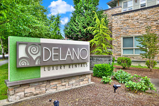 A sign for Delano Luxury Rentals in front of a building.