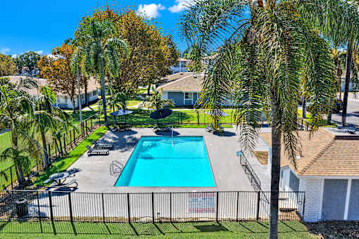 Pool deck with lounge seating and tropical landscaping at Coventry Square Apartments, Upland, 97186