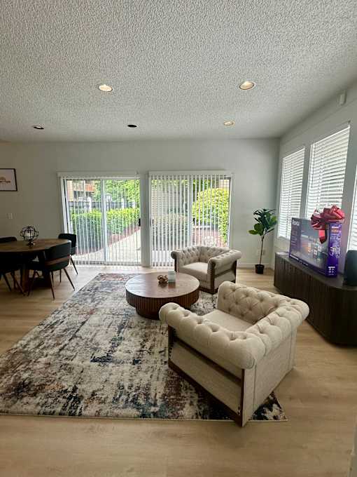 A living room with a rug, a sofa, and a table.