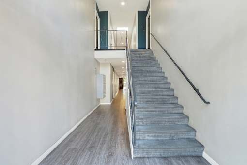 A staircase with a metal railing and wooden steps.at Federal Apartments, Los Angeles, CA