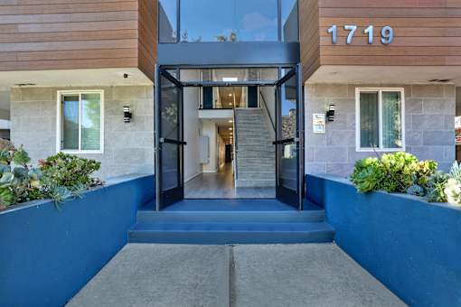 A modern house entrance with a glass door and steps leading up to it.at Federal Apartments, Los Angeles, CA 90025