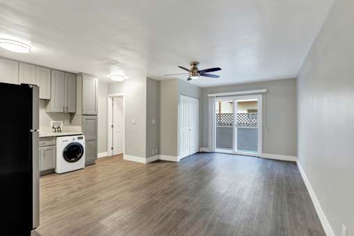 A room with a ceiling fan and a washing machine.at Federal Apartments, Los Angeles