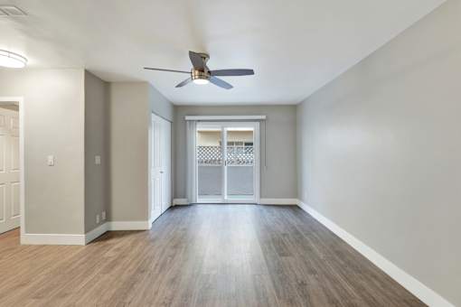 A room with a ceiling fan and wooden flooring.at Federal Apartments, Los Angeles, CA