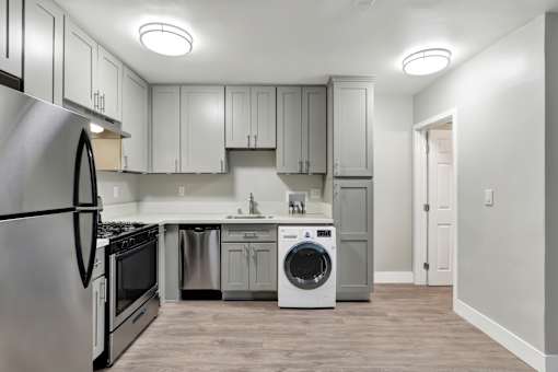 A modern kitchen with a stainless steel refrigerator, microwave, dishwasher, and oven.at Federal Apartments, California, 90025