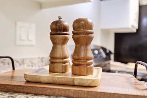 Two wooden salt and pepper shakers on cutting board at La Fayette Marquis, California, 90057