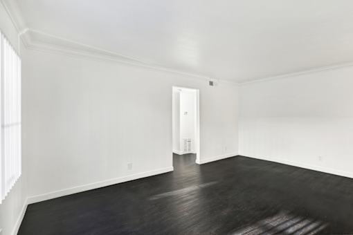 A room with a wooden floor and white walls. at Elmwood Gardens, California