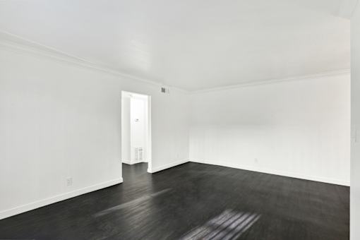 A room with a white door and wooden floor. at Elmwood Gardens, Burbank, California