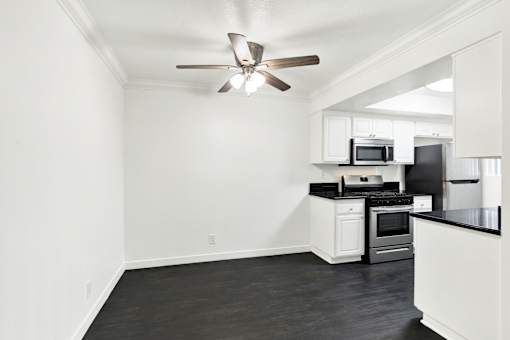 A kitchen with a black countertop and white cabinets. at Elmwood Gardens, Burbank, California