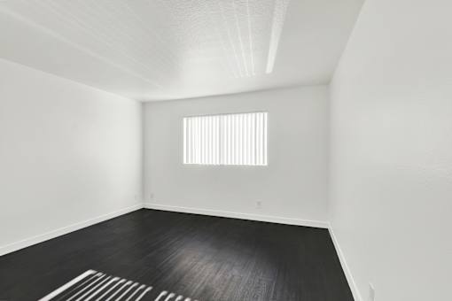 A room with a window and a wooden floor. at Elmwood Gardens, Burbank