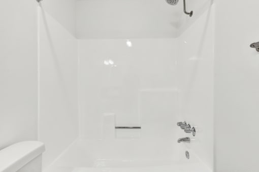 A white bathroom with a toilet and a shower. at Elmwood Gardens, Burbank, 91502