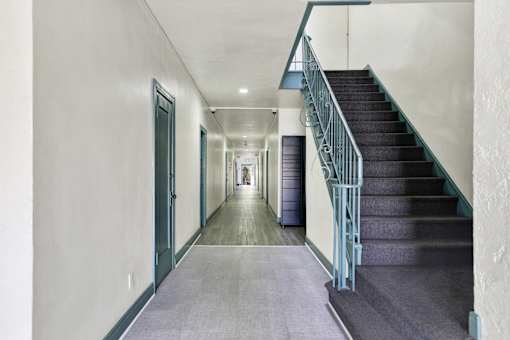 Long hallway with a staircase at Hobart Apartments, Los Angeles, 90029