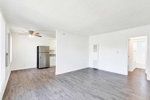 A spacious room with a refrigerator and a ceiling fan at Sylvan Gardens,Van Nuys,California