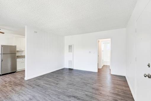A spacious room with wooden flooring and white walls at Sylvan Gardens,Van Nuys,CA,91401