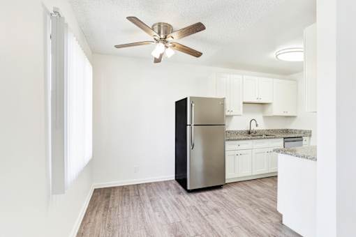 A kitchen with a refrigerator, cabinets, and a ceiling fan at Sylvan Gardens,Van Nuys,California
