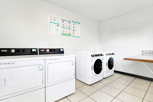 A row of white front load washing machines in a laundromat at Sylvan Gardens,Van Nuys,California