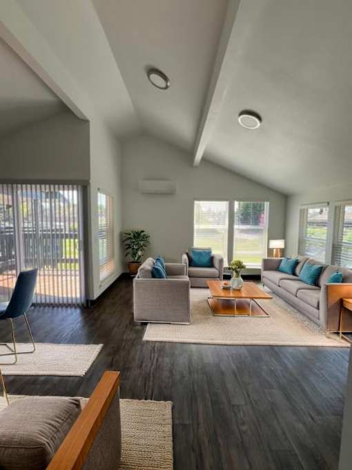 A modern living room with a grey sofa, a blue chair, and a wooden coffee table.