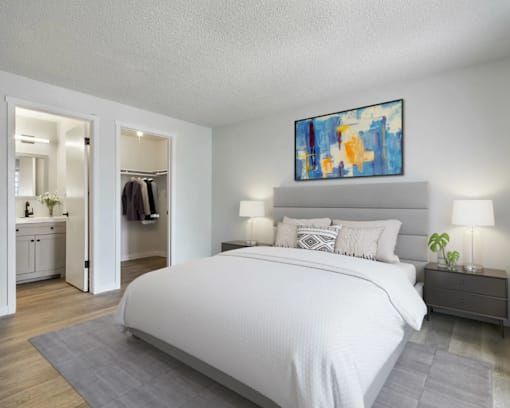 A bedroom with a large bed and a painting above it.