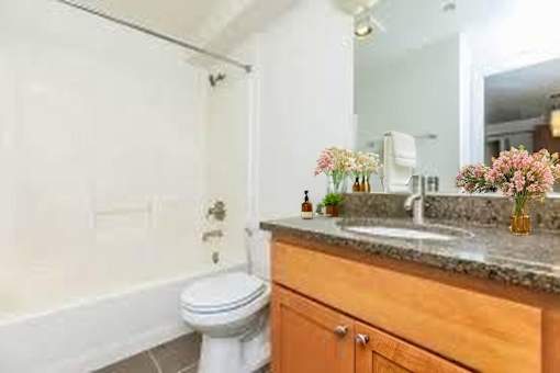 A bathroom with a toilet, sink, and a mirror.