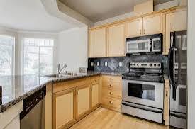 A kitchen with wooden cabinets and black appliances.