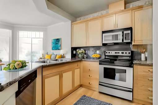 A kitchen with wooden cabinets and a black stove top oven.
