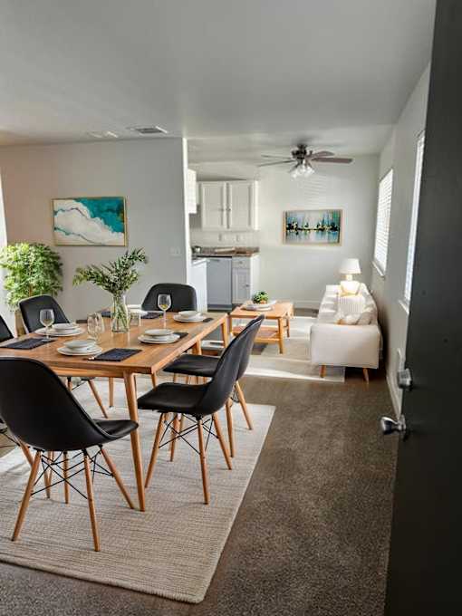 A dining room with a table set for four.