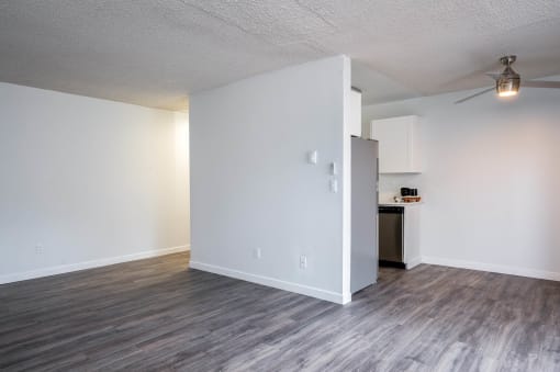 Living room and kitchen with white walls and wood floors at The Ridge at Bellevue, Washington
