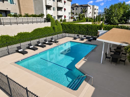 A small pool with a black fence and a black table.