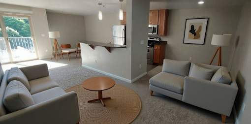 A living room with a grey couch and a brown coffee table.